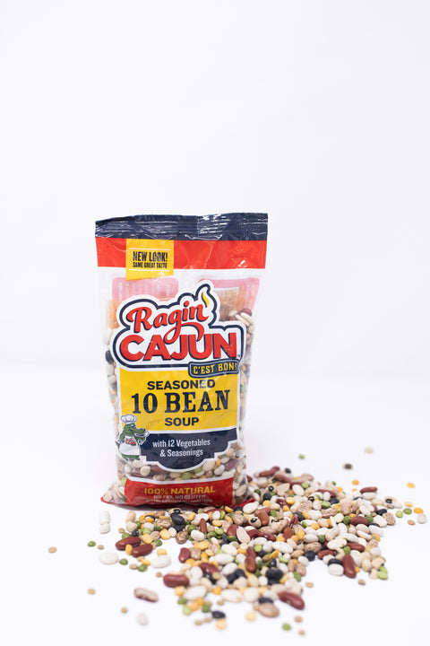Photograph of a Ragin' Cajun Seasoned 10 Bean Soup package featuring a "New Look" banner and a chef alligator mascot on a white background with a colorful spill of diverse dry beans and legumes scattered around