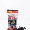 Product photography of Ragin' Cajun Seasoned Black Beans bag featuring a green alligator chef mascot and 'C'est Bon!' slogan, with black beans scattered on a white background