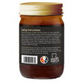 An amber glass jar of Acadian Kitchens gumbo roux with a gold lid, featuring a black label detailing chicken and seafood gumbo cooking instructions, a Certified Cajun Louisiana Product logo with the state outline, and a colorful emblem with a spoon and fleur-de-lis
