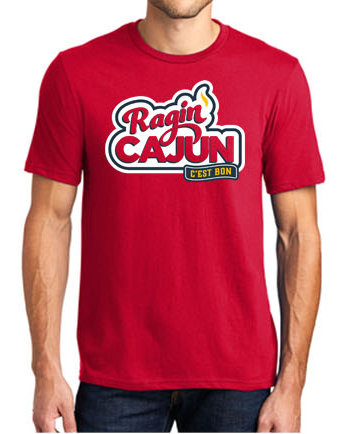 Red t-shirt featuring the bold 'Ragin CAJUN' text in red, white, and blue outline, accented by a yellow flame and a blue banner with 'C'EST BON', representing University of Louisiana at Lafayette culture