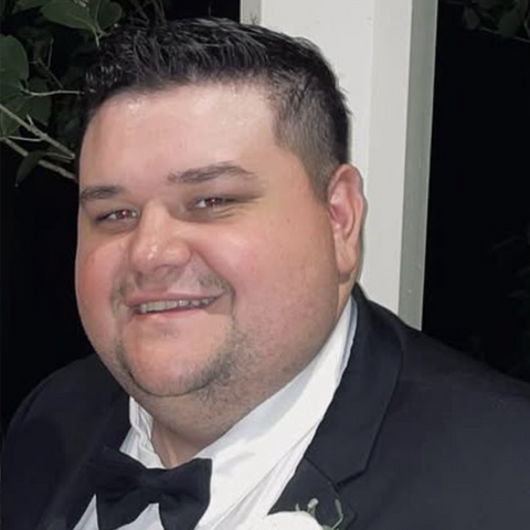 Man wearing a black suit and bow tie indoors