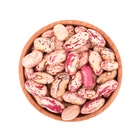 Photograph of colorful pinto beans with distinctive red and cream speckles in a rustic light brown wooden bowl on a white background