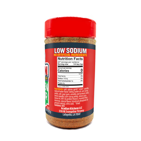 Product photography of an Acadian Kitchens Low Sodium seasoning bottle with a vibrant red cap and label, featuring bold white "LOW SODIUM" text on a dark blue banner, a visible reddish-brown spice blend, and a detailed Nutrition Facts panel from Lafayette LA