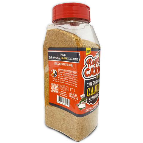 A clear plastic bottle of Ragin' Cajun seasoning with a red flip-top cap, its orange and black label features a cartoon alligator chef and 'Certified Cajun A Louisiana Product' text