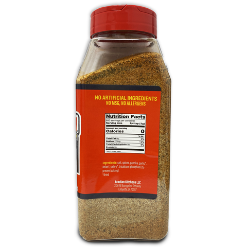 Clear plastic Acadian Kitchens LLC spice bottle with a vibrant red flip-top cap and an orange label displaying Nutrition Facts and ingredients including salt, paprika, and garlic, filled with light brown granular seasoning