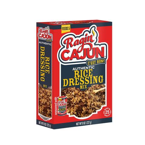 Product shot of a red and dark blue Ragin' Cajun Authentic Rice Dressing Mix box featuring the C'est Bon! logo, an image of prepared rice with a wooden spoon, and labels indicating it feeds 5 and is ready in 25 minutes