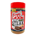 Product photography of a Ragin' Cajun Sizzlin' Steak Seasoning & Rub bottle with a vibrant red lid, a bold red and blue label showcasing a yellow flame graphic, and appetizing images of seared steak and grilled shrimp