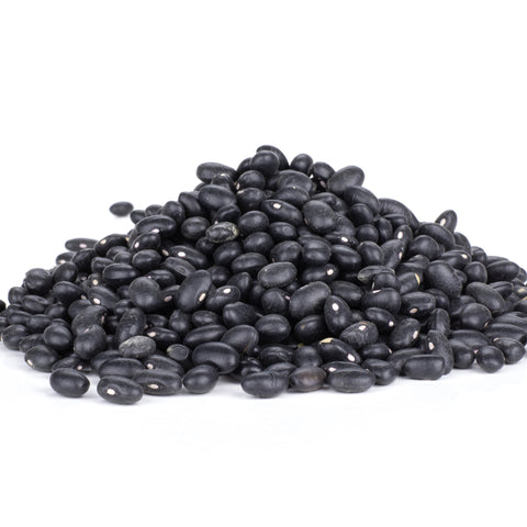 A pile of dried black beans with visible white hilums against a clean white background