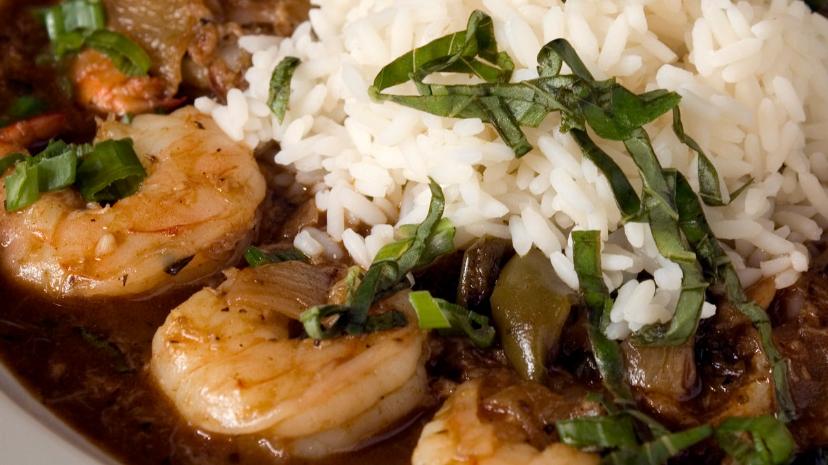 Bowl of seafood gumbo with shrimp, rice, and green onions
