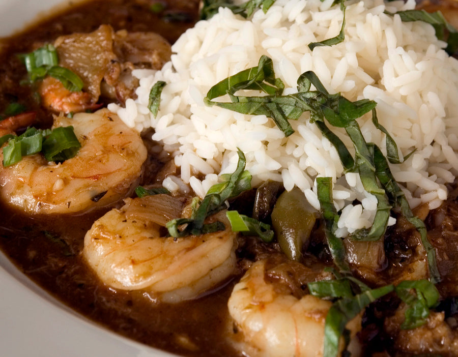 Bowl of seafood gumbo with shrimp, rice, and green onions