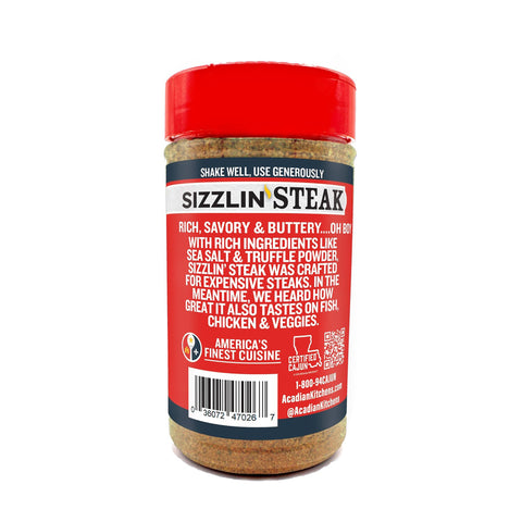 Product photography of an Acadian Kitchens Sizzlin' Steak seasoning bottle on a white background, featuring a vibrant red lid and label with "Sizzlin' Steak" in bold white and yellow, describing it as "rich, savory & buttery" with sea salt and truffle powder, and branded as "Certified Cajun" and "America's Finest Cuisine"